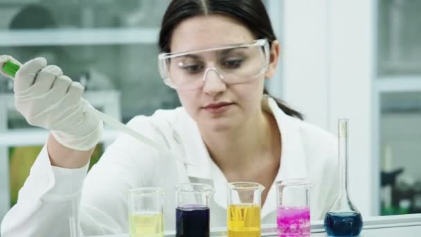 Mujer en laboratorio haciendo experimentos con tubos de ensayo — Vídeo de stock