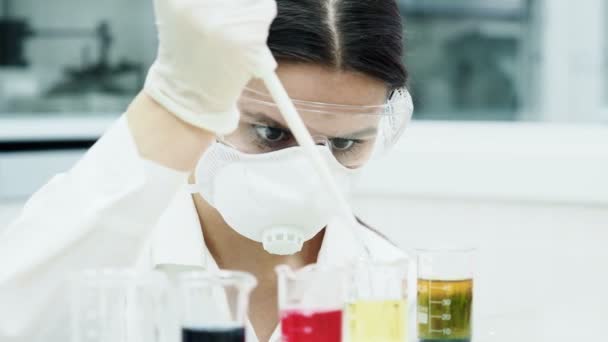Mulher em laboratório a fazer experiências com tubos de ensaio — Vídeo de Stock