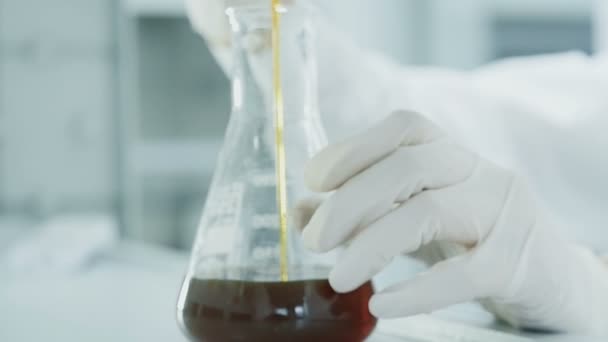 Mãos pesquisador óleo gotejamento em tubo de ensaio em laboratório — Vídeo de Stock