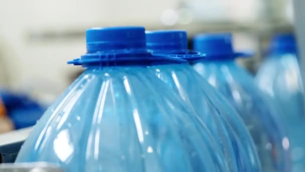 Vrouw plaatst kurken in apparatuur die plastic flessen op transportband bekleedt. — Stockvideo