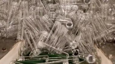 Fabrikadaki üretim konteynırları için plastik preformatlı taşıyıcı bant taşınıyor.
