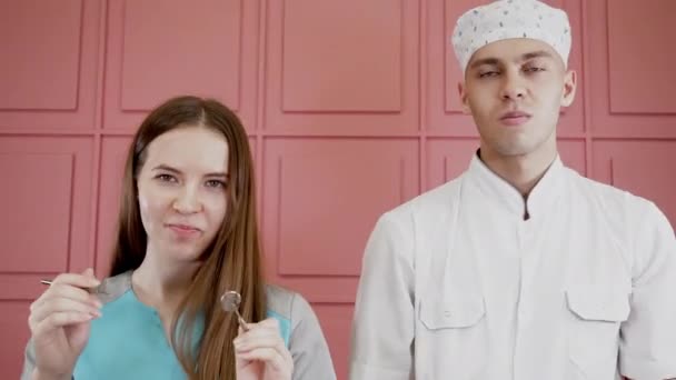 Retratos de dos personas en uniforme médico posando con herramientas dentales y mandíbula — Vídeo de stock