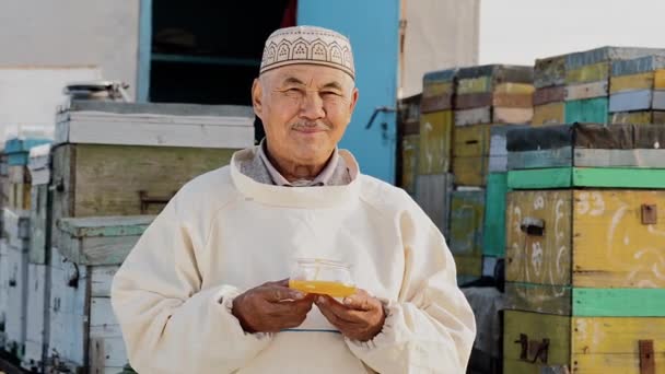 Retrato de sorrir velho agricultor homem segurar recipiente com mel, produção orgânica — Vídeo de Stock