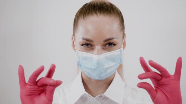 Портрет врача в маске, уверенно смотрящего, поднимающего брови или двигающего пальцами — стоковое видео