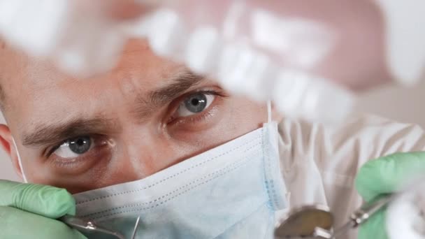 Профессиональный стоматолог в маске с зубными инструментами в руке — стоковое видео