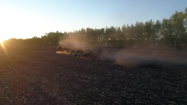 Terreno de trabajo rural por equipo agrícola o tractor en campo de puesta de sol, granja de naturaleza — Vídeo de stock