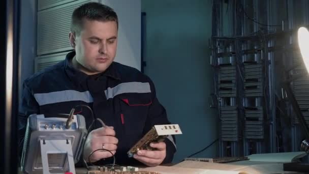 Trabalhador profissional verifica chip de circuito usando instrumento elétrico na oficina — Vídeo de Stock