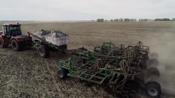 Drönare syn på landsbygdens arbete med industrimaskin på jordbruket på åkermark — Stockvideo