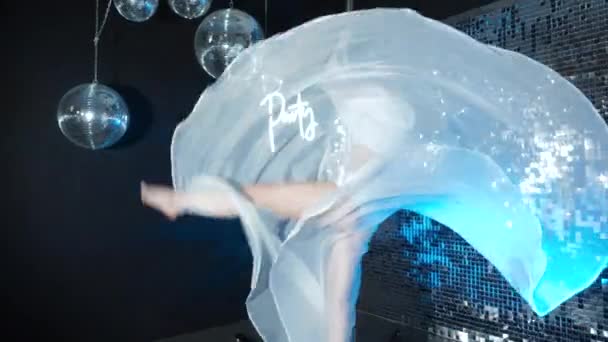 Изящная улыбающаяся танцовщица выступает на шесте на неоновой вечеринке, мастерство танцевальных трюков — стоковое видео