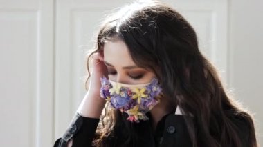 Sakin genç kız freah çiçeklerinden bir maske takıyor, temiz hava soluyor, sağlığın tadını çıkarıyor.