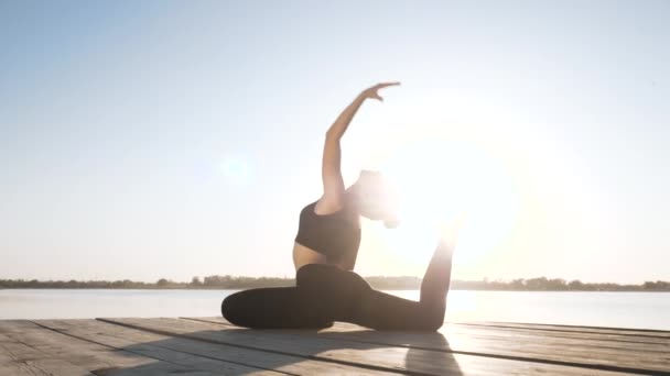 Yoga yapan genç bir kız, dışarıda jimnastik yapıyor. — Stok video