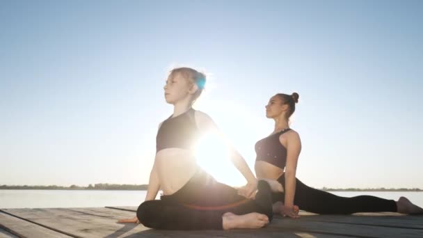 Birlikte jimnastik yapan iki kız çocuğu, vücut çiftli yoga pozisyonu. — Stok video