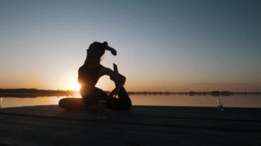 Genç kız yoga yapıyor jimnastik pozisyonu alıyor, egzersiz yapıyor, rahatlıyor.