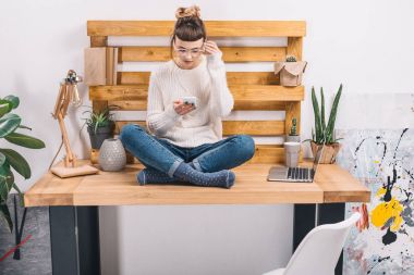 ofiste tabloda oturan ve smartphone vasıl arayan kız