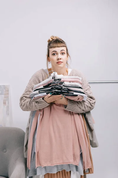 Surprised Girl Holding Stack Clothes Hangers Looking Camera — Stock Photo, Image