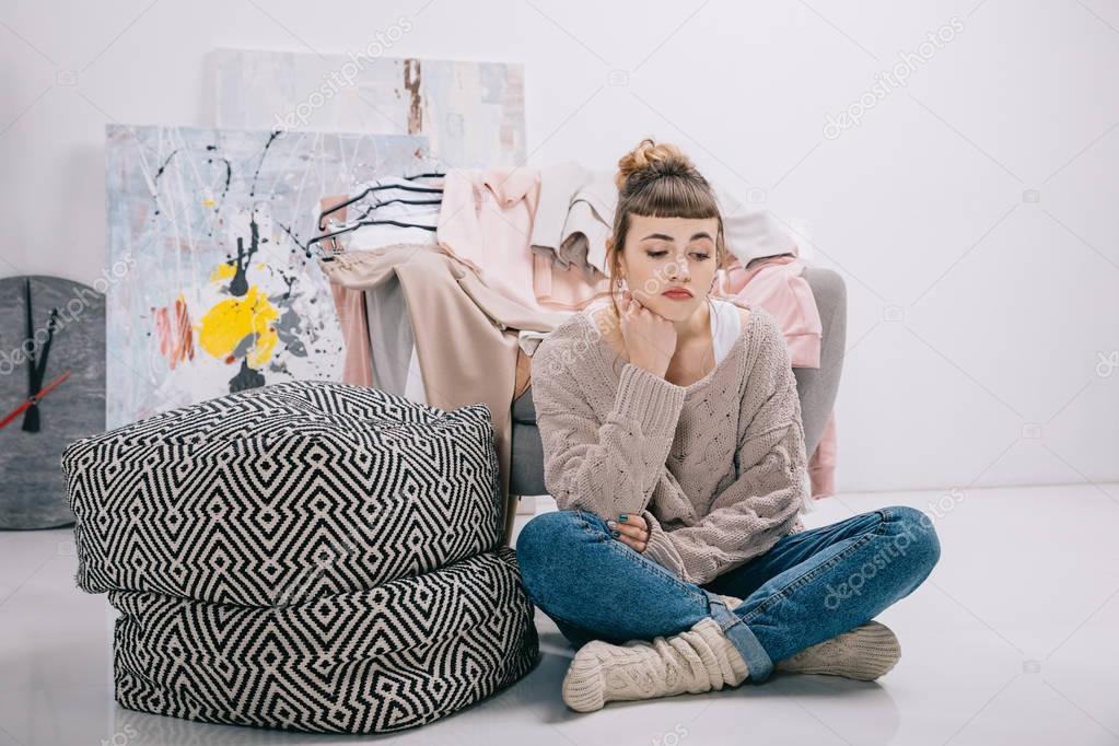 upset girl sitting on floor and looking down