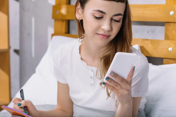Happy Girl Sitting Bed Morning Looking Smartphone — Free Stock Photo