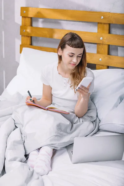 Happy Girl Sitting Bed Morning Looking Smartphone — Free Stock Photo