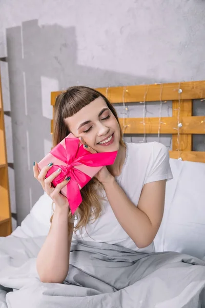 Smiling Girl Touching Gift Box Face — Free Stock Photo