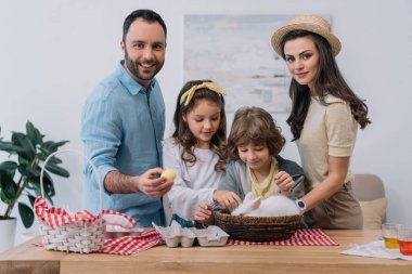 Genç aile renkli yumurta ve tavşan Paskalya için hazırlanıyor
