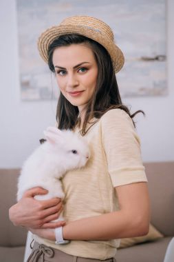 sevimli beyaz tavşan tutarak şapkalı şık kadın