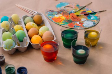 freshly painted easter eggs with paint on table clipart