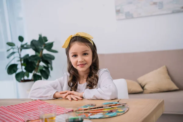 Lächelndes Kleines Kind Mit Palette Und Farbe Blickt Die Kamera — kostenloses Stockfoto