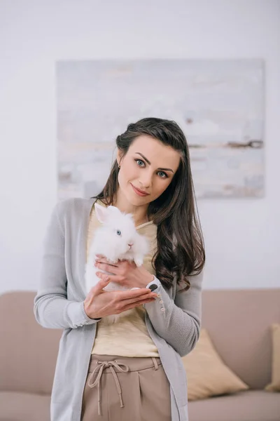 Attractive Woman Holding White Rabbit Looking Camera Indoors — Free Stock Photo