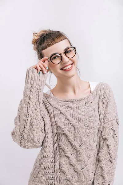 Lächelndes Mädchen im Stehen und Brille auf weißem Grund anfassen — Stockfoto
