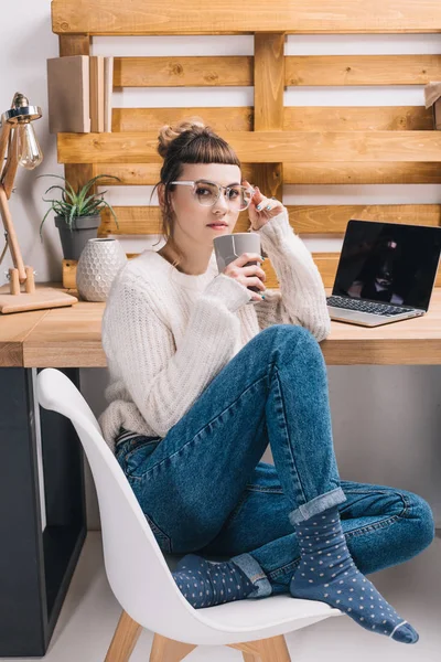 Office worker sitting on chair and drinking tea — Stock Photo