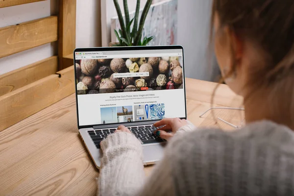 Abgeschnittenes Bild eines Mädchens, das mit Laptop mit geladener Hinterlegungsfotoseite sitzt — Stockfoto