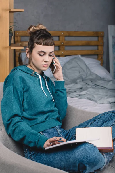 Girl working from home and talking by smartphone — Stock Photo