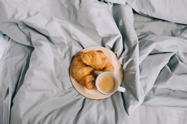 Vista superior da placa com croissants e café em cobertor cinza — Fotografia de Stock