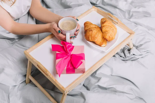 Abgeschnittenes Bild eines Mädchens, das eine Tasse Kaffee auf Tablett hält — Stockfoto