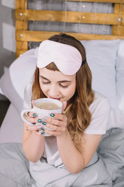 Vista aérea de la niña bebiendo café en la cama por la mañana - foto de stock