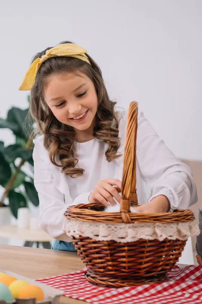 Little child touching furry pet in basket on easter holiday — Stock Photo