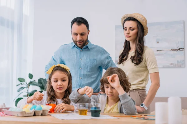 Young family painting eggs for easter holiday at home — Stock Photo