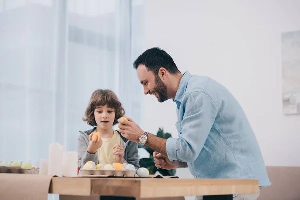 Handsome young father and son painting easter eggs — Stock Photo