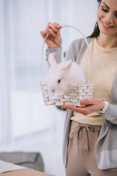 Attraktive junge Frau mit weißem Kaninchen im Korb — Stockfoto