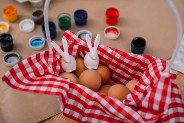 Пасхальные яйца с фигурками кроликов в корзине — стоковое фото