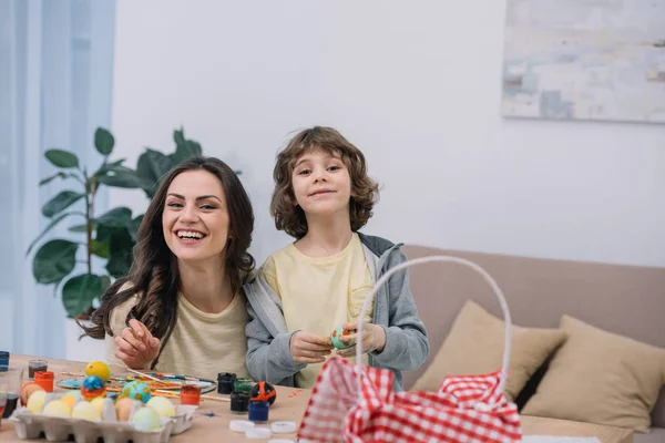 Mother and son spending time together while painting easter eggs together at home — Stock Photo