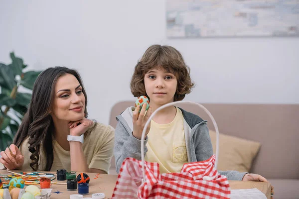Mother and son painting easter eggs together at home — Stock Photo