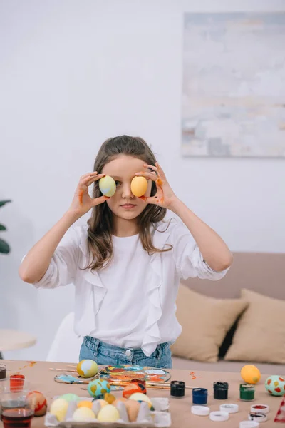 Petit enfant couvrant les yeux avec des œufs de Pâques — Photo de stock