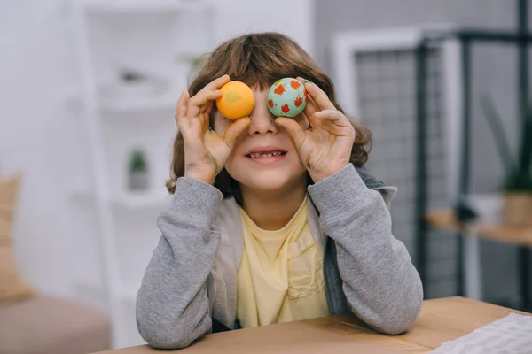 Kleines Kind bedeckt Augen mit Ostereiern — Stockfoto