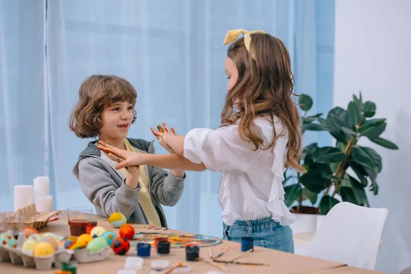 Kids playing while painting easter eggs for holiday — Stock Photo