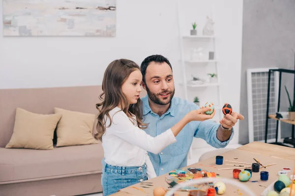 Father with daughter looking at freshly painted easter eggs — Stock Photo