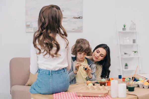 Kids painting easter eggs mother at home with mother — Stock Photo