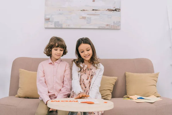 Kinder bereiten Gruß für Muttertag zu Hause auf Couch vor — Stockfoto