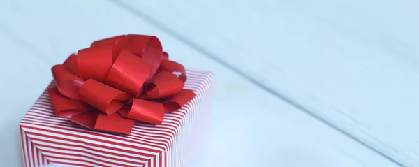 gift box with red bow and hearts on light background