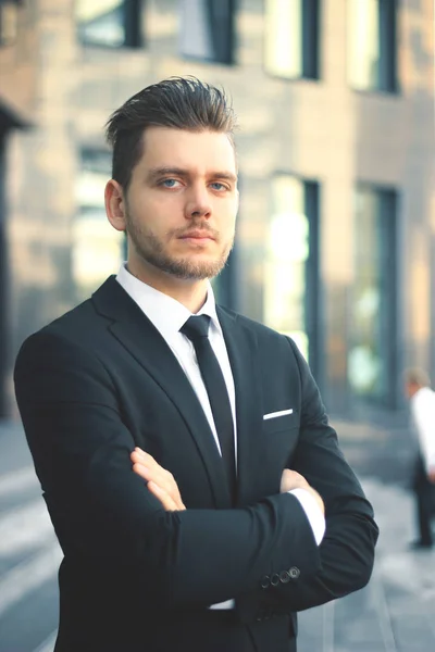 Retrato de un exitoso hombre de negocios en el fondo de un edificio de oficinas — Foto de Stock